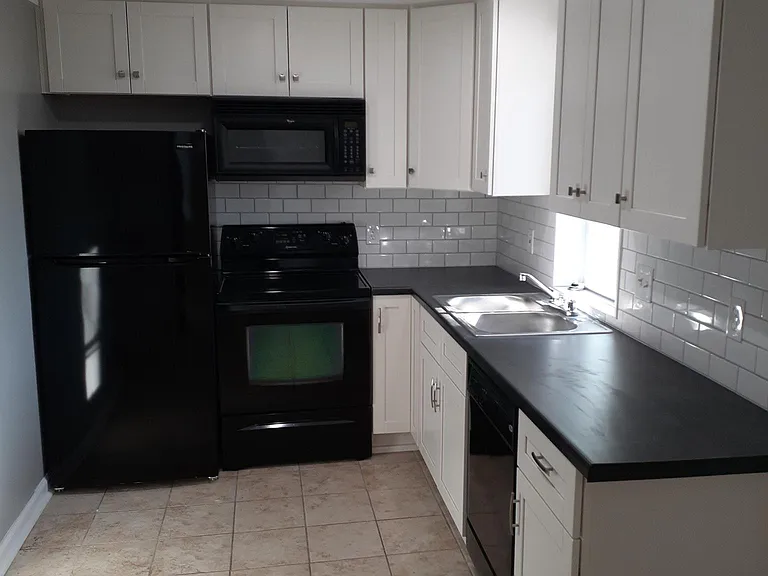 Kitchen with dishwasher, range, microwave and fridge.