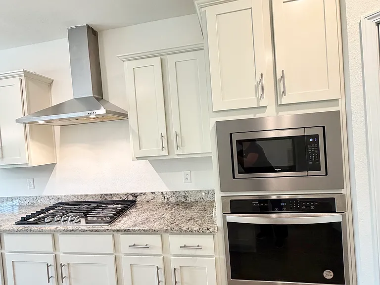 Kitchen with granite counter top & stainless steel appliance