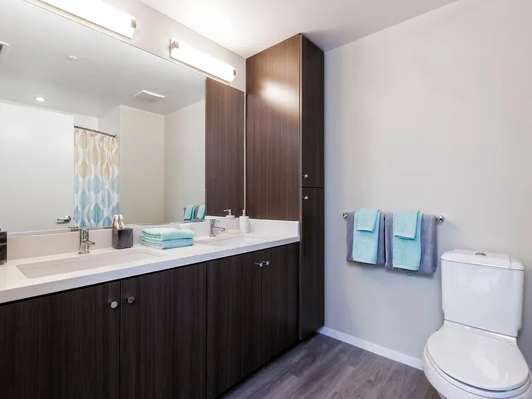 Bathroom with dark brown cabinetry, white countertop and hard surface flooring