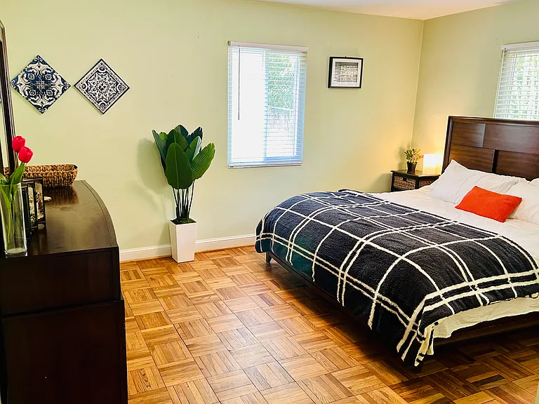 Master Bedroom with a King-sized Bed and a large dresser with mirror.