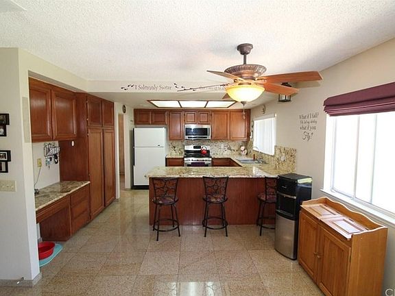 Spacious Kitchen that features Beautiful granite founder tops and back splash, Built-in Microwave, Pantry, Desk, and a Bar style Breakfast area.