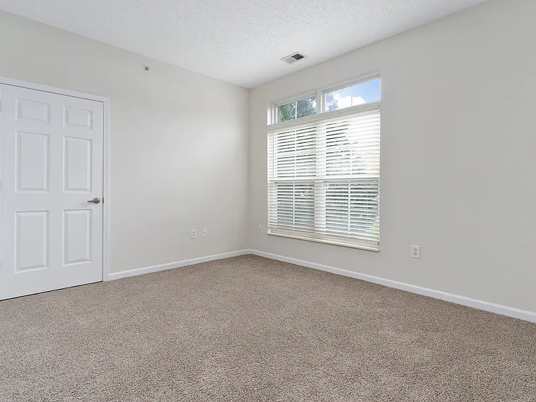 The Charleston Magnolia Premium Renovated Bedroom offering abundant natural light through transom windows