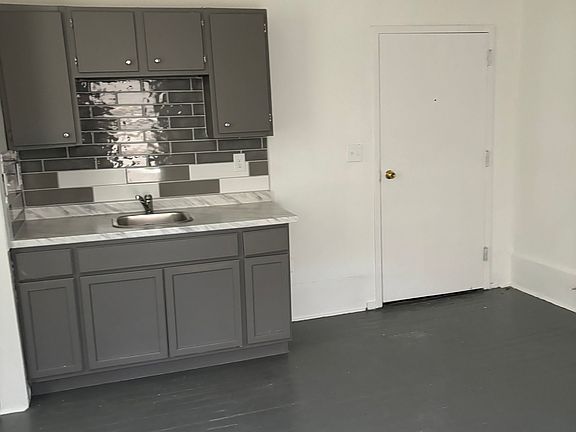 this is the living room and kitchen area it has a stove and fridge that were recently put in