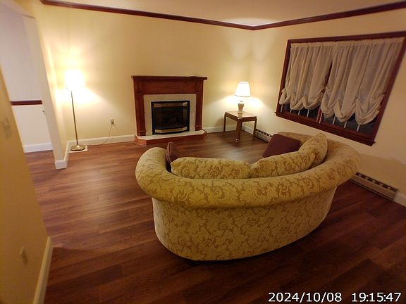 Living room includes furnishings and propane fireplace controlled by wall thermostat