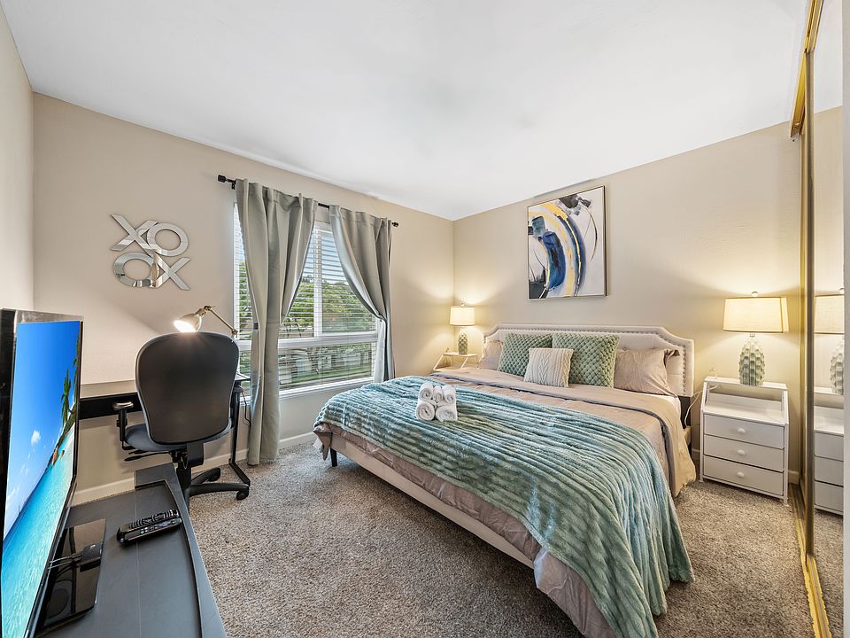 Spacious master bedroom with a king bed, workspace, and TV for comfort and convenience.