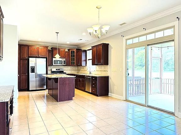 Tile floor in the kitchen and dark color cabinets are easy to clean and maintain.