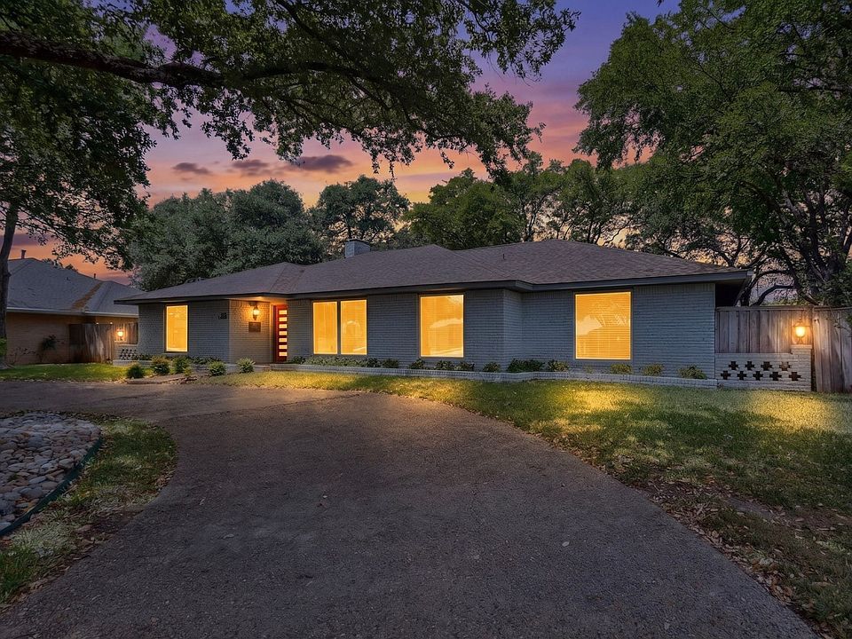 A cozy house with a driveway surrounded by trees