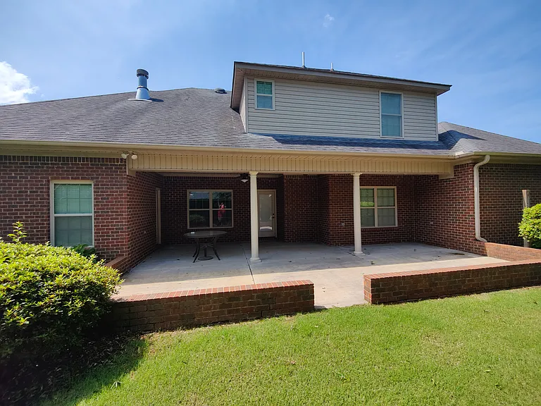 Large porch in the back side. Upper level bedroom and bathroom windows.