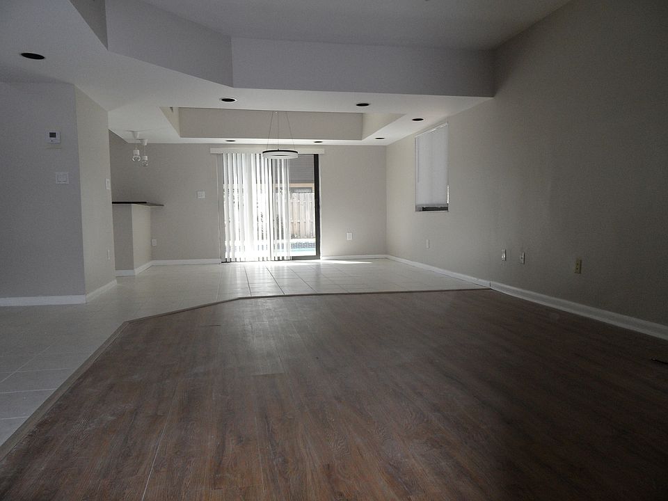 Nicely sized living room/dining room area; neutral flooring and walls.
