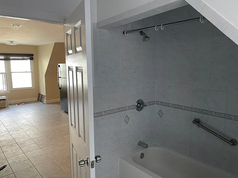 BATHROOM, TUB/SHOWER AND VIEW OUT INTO KITCHEN/LVING AREA