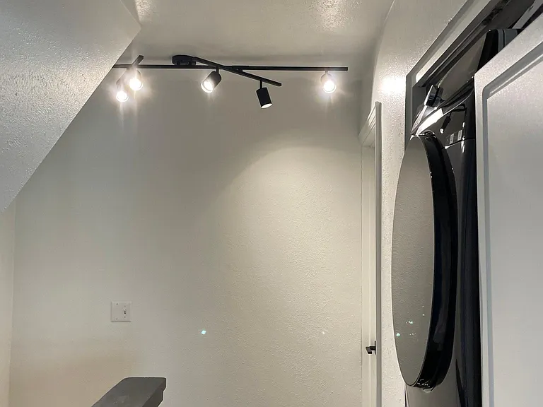 Upstairs hallway with stacked washer dryer and storage cabinet
