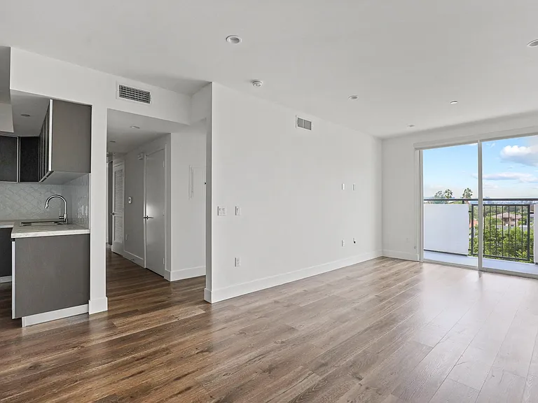 Open-Concept Kitchen, Dining, and Living Room Space with Patio