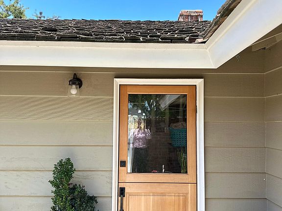 Custom wood dutch door greets you once inside the private courtyard