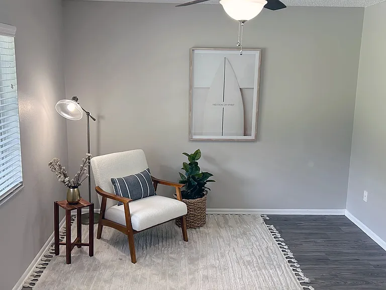 Experience the chic and cozy living area featuring wood-style flooring and ample natural light. Perfect for relaxing or entertaining, this inviting area offers a stylish and serene environment for all your needs.