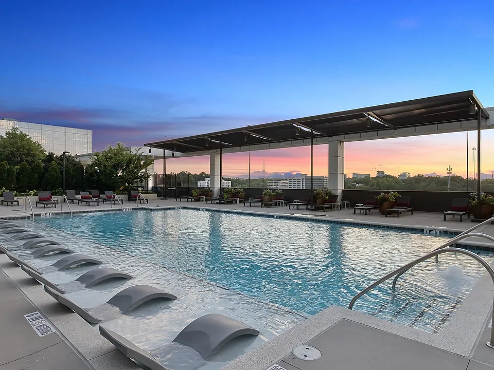 Resort-style pool with lounge seating and sun shade