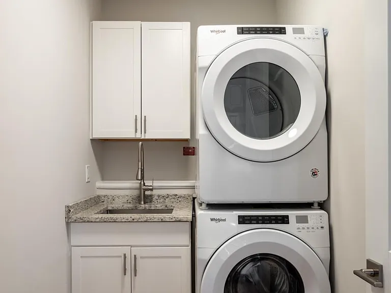 Private First Floor Laundry with Expansive Cabinetry and Stackable Whirlpool Washer and Dryer