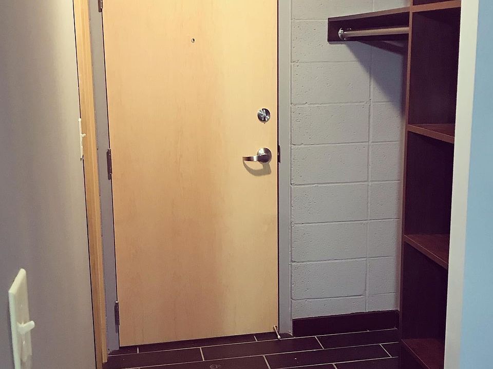 Front door and closet area when standing inside the apartment. To the left is a bathroom.