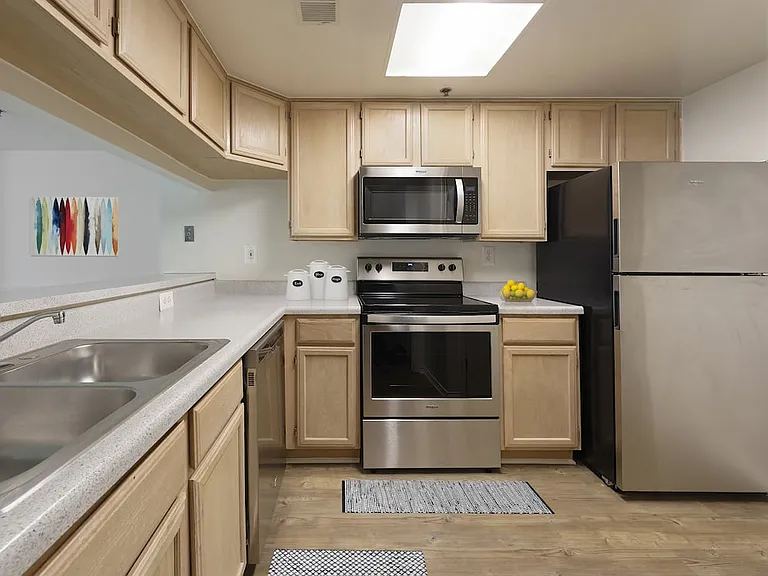 Classic Package I kitchen with grey countertops, oak cabinetry, stainless steel appliances, and hard surface flooring