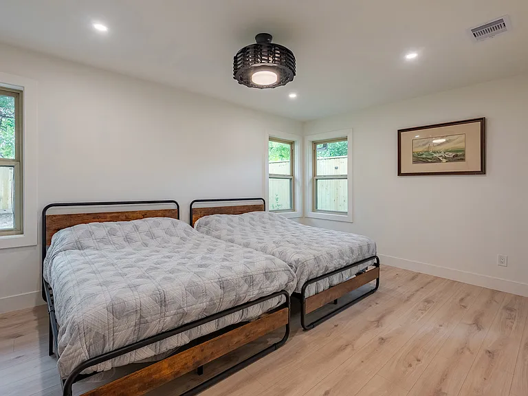 Spacious primary bedroom with large windows, soft natural light, and serene ambiance.
