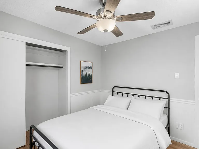 Neatly finished bedroom with ceiling fan, open closet storage, and easy access to adjacent living areas.