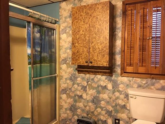 BATHROOM HAS 4 FT. SHOWER WITH A SEAT AND CABINETS MADE BY AN ENGLISH CABINET MAKER. SHOWER CURTAIN ANS ROD NEED TO BE REPLACED.