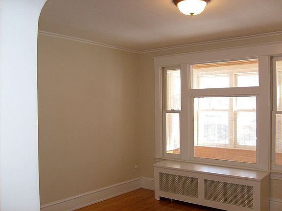 Living room with hardwood floors, a large window, and walks out ot a porch!