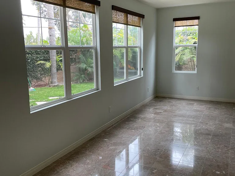 FAMILY ROOM WITH MARBLE FLOORING AND RATTAN ROLLER BLINDS
