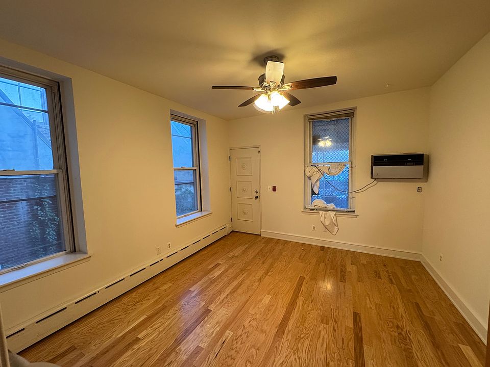 bedroom with three windows NEW hardwood floor ceiling fan with light
