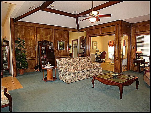 Large wood paneled den has vaulted ceiling with exposed beams