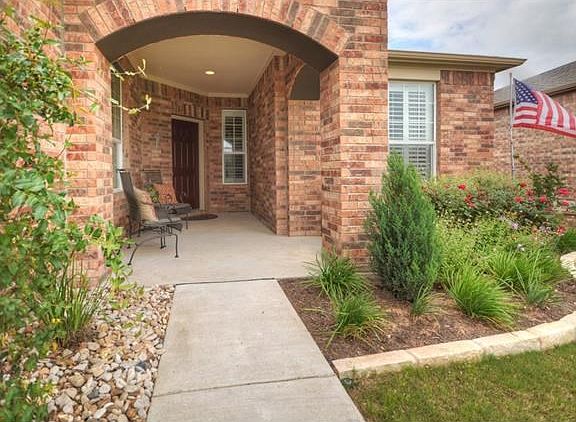 Nicely landscaped beds are seen as you approach the front porch of this Surrey Crest.