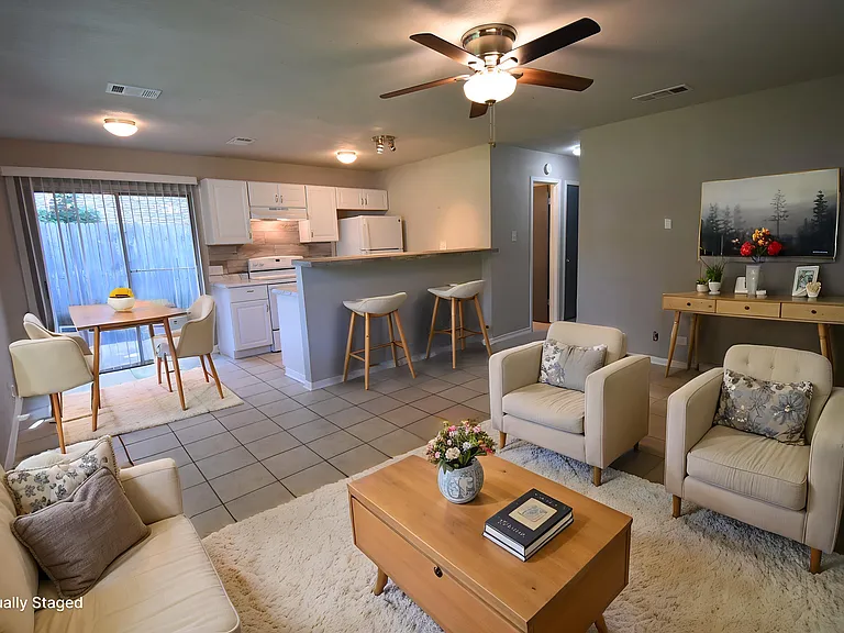 Open Floor plan! Virtually staged living room with large windows and a ceiling fan.