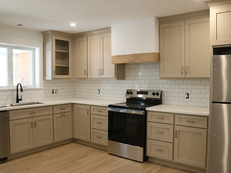 custom kitchen with subway tile backsplash and stainless appliances