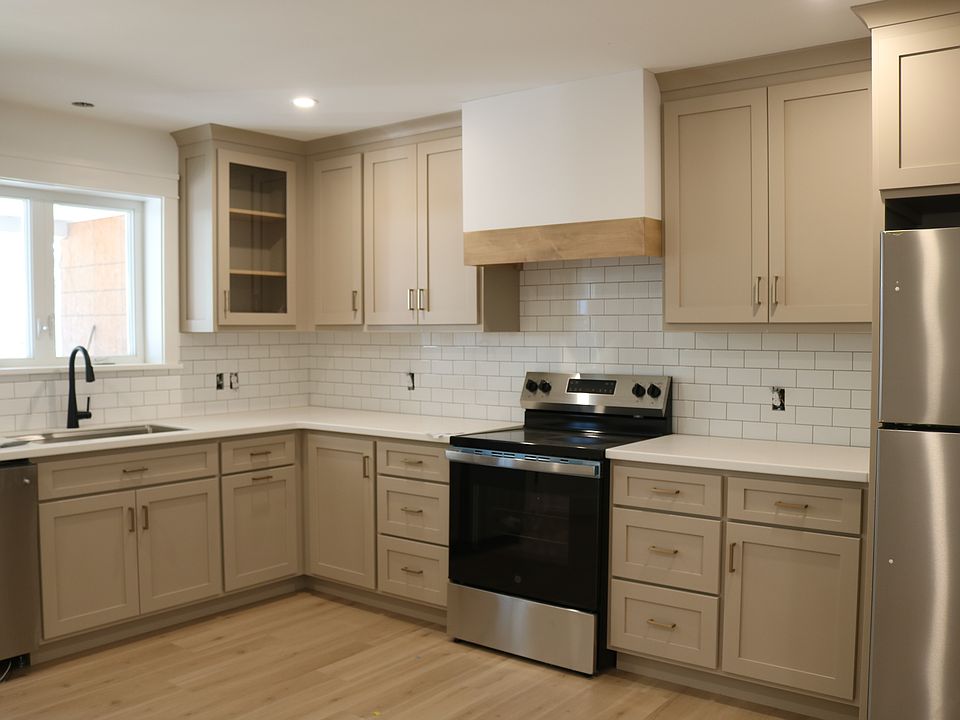 custom kitchen with subway tile backsplash and stainless appliances