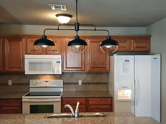 Kitchen with pantry, microwave, refrigerator with ice maker on the door, and plenty of storage!