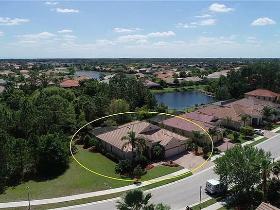 Aerial view of the home on the oversized with privacy and mature landscaping including palms and weeping bottle brush trees.