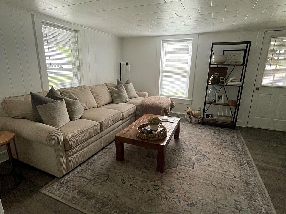 Living room features 2 windows, and front entrance door