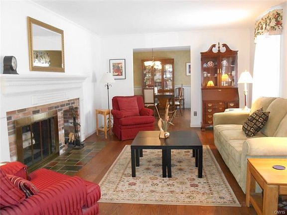 Sunny Living Room Features Rich Pegged Oak Floors and a Wood-burning Fireplace with Attractive Mantle