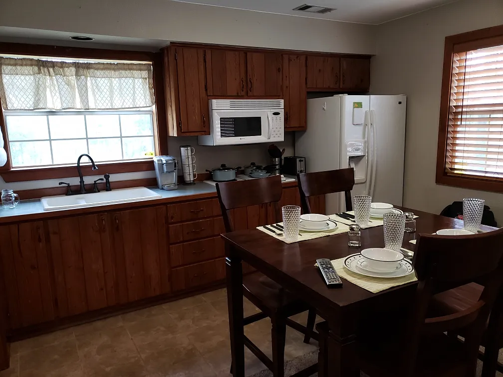 Kitchen and dining area. Coffee maker, microwave, refrigerator, table and chairs. - 18324 Cusachs Dr
