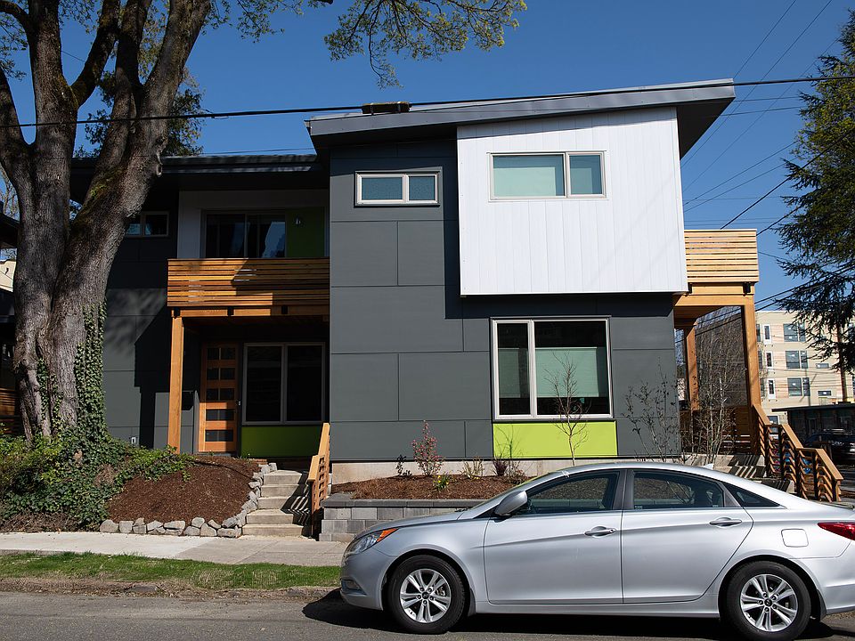 View from NE 27th Ave. The unit is the one under the big tree. It has a front porch on the main floor and a balcony on the 2nd floor.