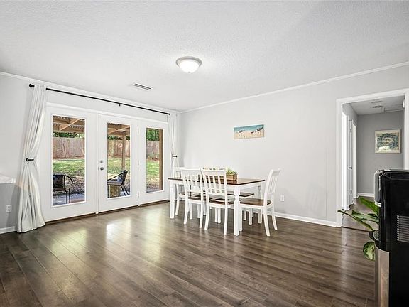 Dining space featuring french doors, crown molding, a textured ceiling, and dark hardwood / wood-style floors