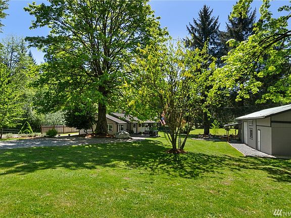 Looking across from the carport, cozy rambler on the left and detached studio office and shop space to the right also the electronic well room is through the white door on the right. Garage has unfinished space above.
