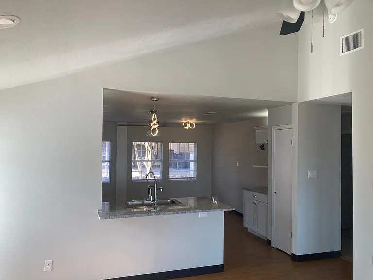 kitchen sink and dining area. Note the light fixtures and vaulted ceiling