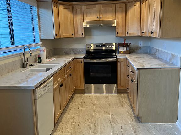 Remodeled kitchen with new cabinets, new quartz counters, new floor and new stove.
