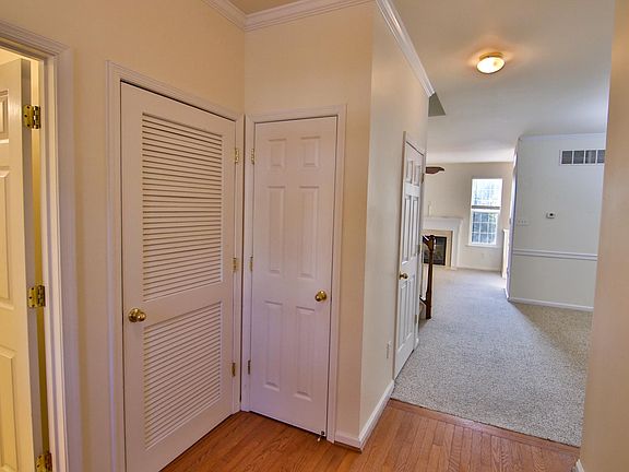 Hardwood floor entry foyer with 1/2 bath and laundry to the left; garage entrance to the right