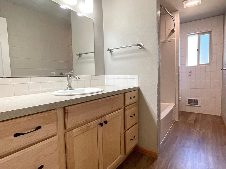 Large bright and shiny bathroom is easy to care for. Loads of white subway tile and brushed metal trim. Adult height cabinets with ample storage for everyone.