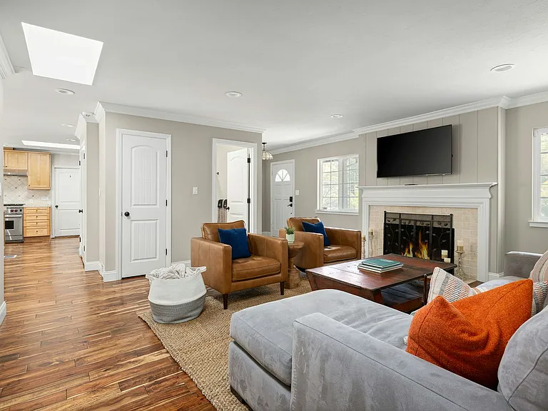 Bright, comfortable, and open this living room offers a perfect blend of relaxation and flow, with a fireplace for cozy nights and sightlines into the kitchen for easy everyday living.