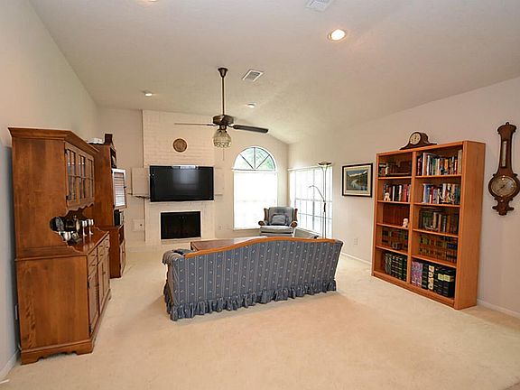 Spacious family room featuring raised ceilings, ceiling fan, recessed lighting, romantic fireplace a