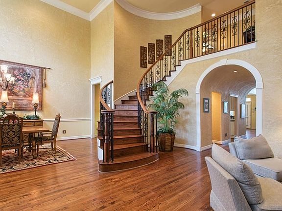 Grand entrance is graced with a rotunda ceiling leading the way to the family room and kitchen. This beautiful home hosts wrought iron front staircase and a back staircase near kitchen.