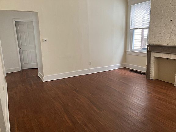 View from main bedroom through living room towards bathroom in short hall.