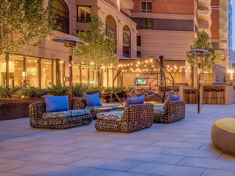 Outdoor chill space with fireplace, lounge seating, barbecue grills and dining area